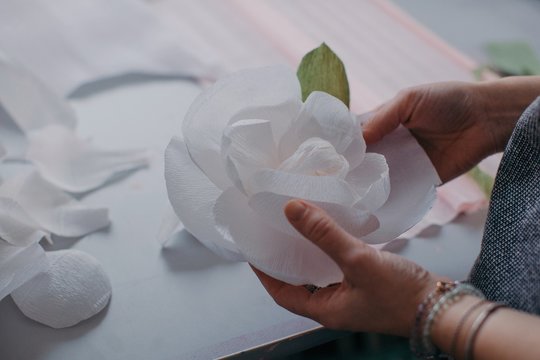 Crop hands creating beautiful paper flower