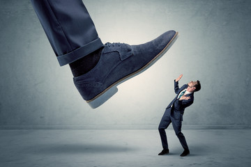 Demoralised employee symbolized by small man getting trampled