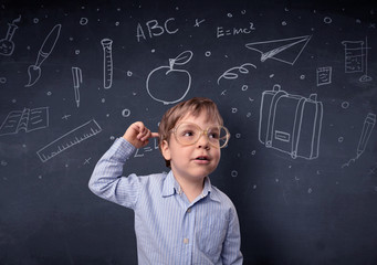Smart little kid in front of a drawn up blackboard ruminate
