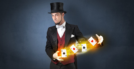 Illusionist in tails bandy play cards between his two hands