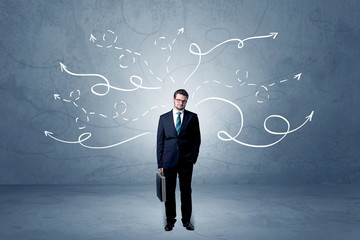 Elegant businessman choosing between directions with winding drawn arrows around 
