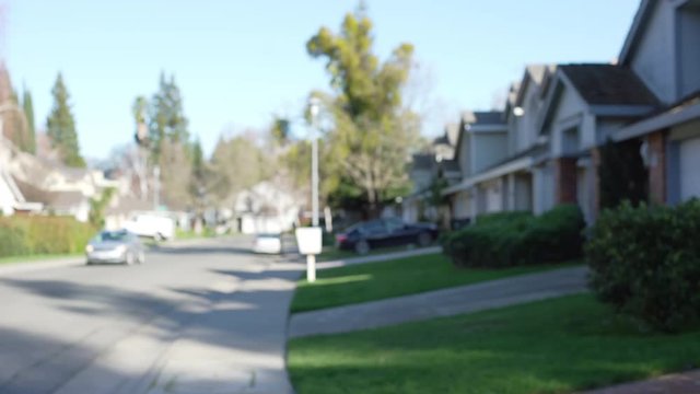 Side view of suburban houses with green manicured lawns down a street