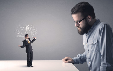 Young professional businessman being angry with an other miniature businessman who has scribbles...