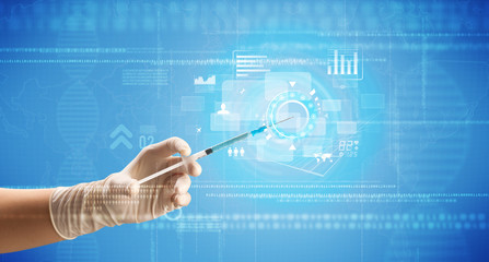 Female doctor hand holding syringe with blue background and charts