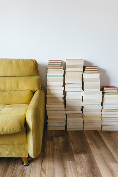Retro yellow sofa and stacks of books