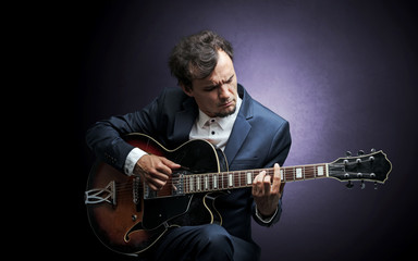 Obraz premium Lonely guitarist composing on cello with nothing around 