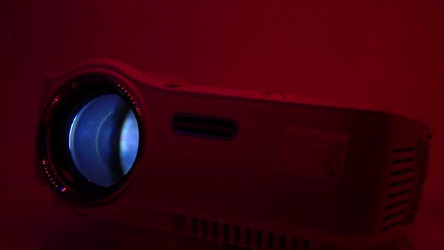 Close Up of LED Projector Bright Light and Romantic Red Background Lighting.