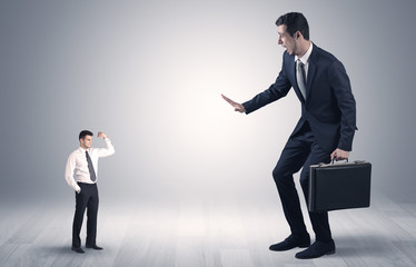 Big debutant young businessman scared of small strong businessman
