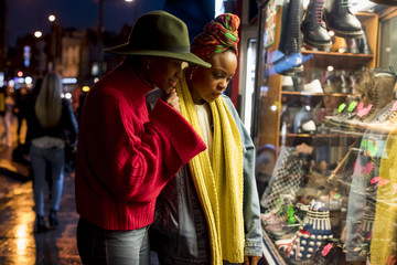Stylish women looking a showcase of a shop