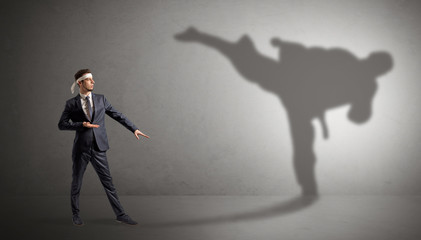 Young karate man confronting with his own shadow
