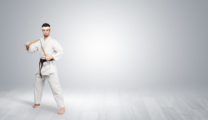 Fototapeta na wymiar Young kung-fu trainer fighting in an empty space 