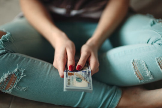 Anonymous woman holding new modern hundred dollar bills