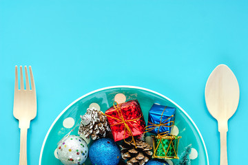 Polka dot plate of Xmas ornaments and decoration with wooden spoon and fork on blue background for Christmas day and holidays concept