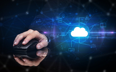 Hand using wireless mouse in a dark environment with cloud technology and online storage concept