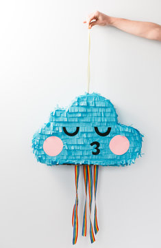 cute pastel paper party cloud pinata behind a white wall