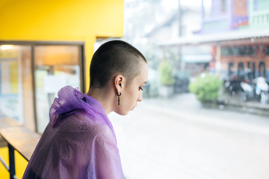 Stylish woman with crewcut dressed in a purple raincoat