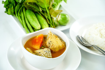 Thai Food,A white bowl of hot and sour yellow curry paste soup with fish and green papaya served with fresh mixed vegetable. Southern Thai traditional food with selective focus.1