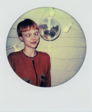 Fun polaroid scan of a young woman making funny faces next to a mirrorball
