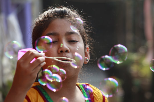 Teenage girl making fun with soap bubbles