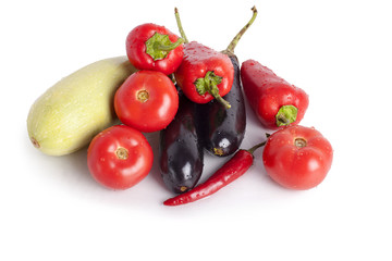 Tomatoes, red sweet peppers, red hot chilli peppers, violet eggplants, green zucchini in drops of water, sprinkles, drops of dew on white background closeup top view isolated