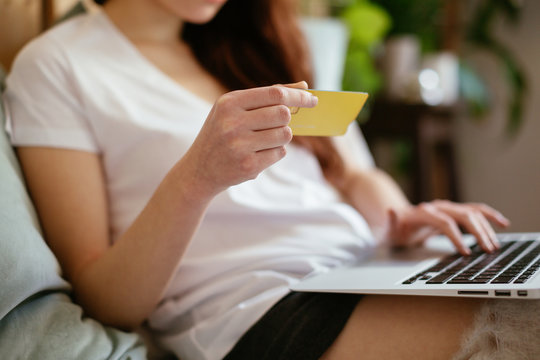 Young woman shopping online resting in bed.
