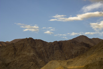 blue sky with clouds over the sandy mountains