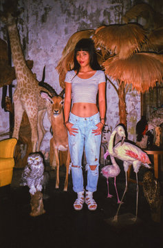 Asian young woman standing in the room filled with wild animal