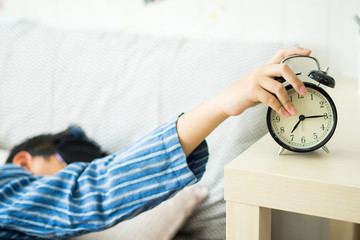 A kids waking up to an alarm clock in the bedroom
