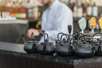 Herbal tea in teapots on bar counter in spa salon