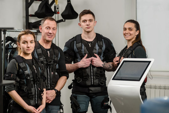 Four happy athletes after EMS training at gym