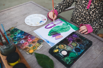 Close up of a child painting with watercolor