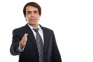 Studio shot of young Persian businessman giving handshake