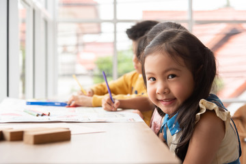 Asian Little girl with Smiling face in a classroom at a school.