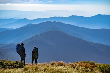 The two people standing on the mountain