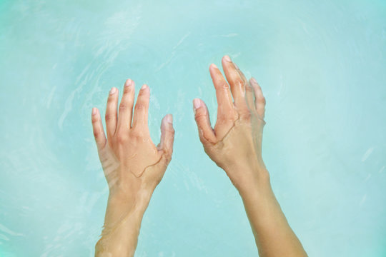 Woman's hands in blue water