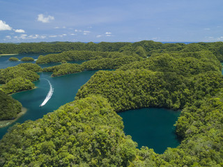 Fototapeta premium Aerial shot of Palau Rock islands with speed boat travelling through frame