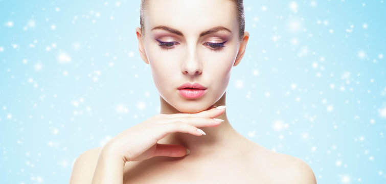 Portrait of young, beautiful and healthy woman over winter Christmas background.