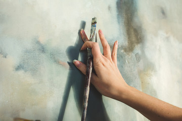 Close up of an artist's hand with brush