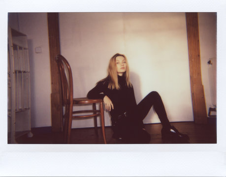 Fototapeta Confident blonde in black sitting on floor