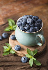 blueberry in a cup on a wooden background