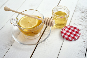 delicious hot tea with lemon and honey on an old white wooden table
