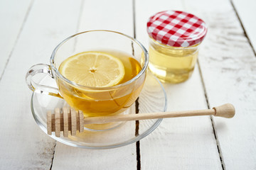 delicious hot tea with lemon and honey on an old white wooden table