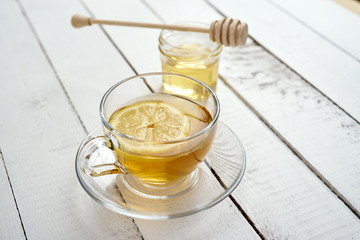 delicious hot tea with lemon and honey on an old white wooden table