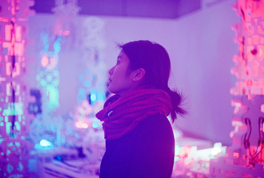 Portrait of woman standing in front of colorful lights