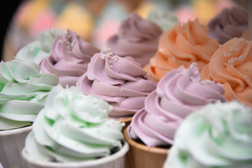 Close up Cup Cake vanilla cream topping pastel colour event on shelve decoration