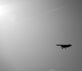 Light aircraft flying towards sun light in the sky
