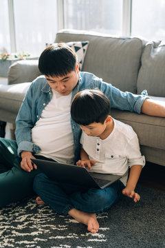 Father and son using laptop at home