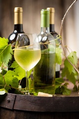 Wine bottles and a glass on a barrel