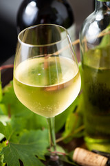 Wine bottles and a glass on a barrel