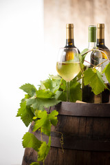 Wine bottles and a glass on a barrel